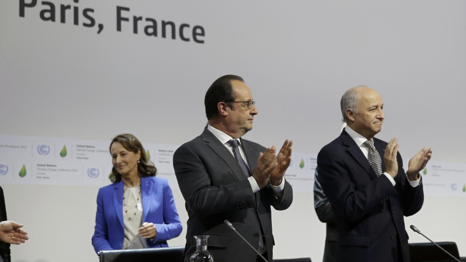 ‪‬ الرئيس الفرنسي فرانسوا هولاند ووزير الخارجية لوران فابيوس أثناء جلسة توقيع الاتفاق(رويترز)