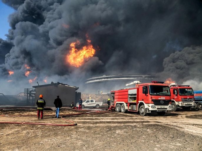 Firefighters trying to put out the fire in an oil tank in the port of Es Sider, in Ras Lanuf, Libya, January 6, 2016. Firefighters have extinguished two fires at oil storage tanks at Libya's Ras Lanuf terminal, but blazes continue at five tanks in the nearby port of Es Sider after attacks this week by Islamic State militants, a Petroleum Facilities Guards (PFG) spokesman said on Thursday. Picture taken January 6, 2016. REUTERS/Stringer EDITORIAL USE ONLY. NO RESALES. NO ARCHIVE