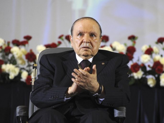 FILE - In this April 28, 2014 file photo, Algerian President Abdelaziz Bouteflika, sitting in a wheelchair, applauds after taking the oath as President in Algiers. One year after he was re-elected to a fourth term, the absence of Algeria’s stroke-hit president from daily life is being felt more keenly than ever as this oil-rich North African nation is facing unprecedented economic and political challenges. (AP Photo/Sidali Djarboub, File)