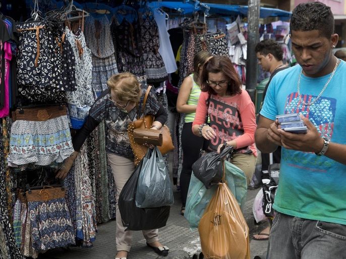 People shop in Sao Paulo, Brazil, Tuesday, Dec. 1, 2015. Latin America's largest economy has shrunk even more than expected, increasing fears about the well-being of a nation hammered by falling commodity prices and a massive corruption scandal. (AP Photo/Andre Penner)