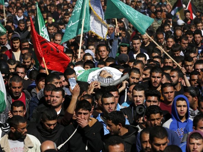 Palestinians carry the body of 23 years old Mohammad Kawazbeh during his funeral in the West Bank village of Sae'er, 13 January 2016. Kawazbeh was shot dead at a checkpoint near Hebron after he tried to stab an Israeli soldier on 12 January.