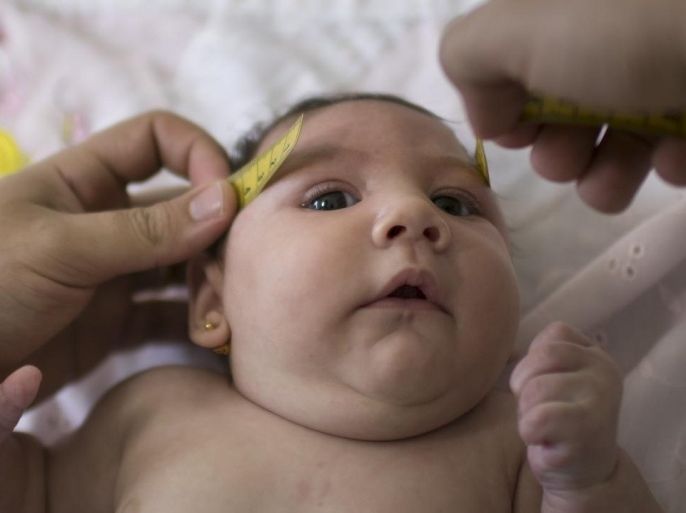 In this Dec. 22, 2015 photo, Luiza has her head measured by a neurologist at the Mestre Vitalino Hospital in Caruaru, Pernambuco state, Brazil. Luiza was born in October with a head that was just 11.4 inches (29 centimeters) in diameter, more than an inch (3 centimeters) below the range defined as healthy by doctors. Her rare condition, known as microcephaly, often results in mental retardation. (AP Photo/Felipe Dana)