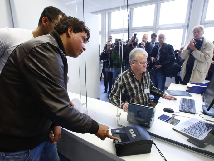  أخذ بصمات أحد اللاجئين في مركز تسجيل بمدينة هايدلبرغ بألمانيا أمس (رويترز)