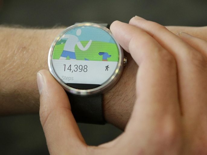 FILE - In this June 25, 2014 file photo ,a man wears a Moto 360 by Motorola, an Android Wear smartwatch, on the demo floor at Google I/O 2014 in San Francisco. (AP Photo/Jeff Chiu, File)