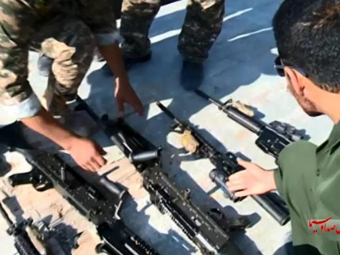 ‪بعض أفراد الحرس الثوري الإيراني يقومون بفرز قطع السلاح التي استولوا عليها من البحارة الأميركيين‬ (أسوشيتد برس)