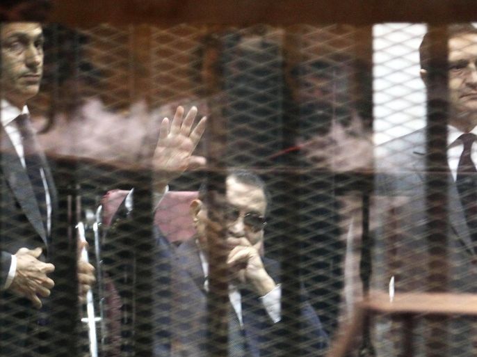 (FILE) A file photo dated 09 May 2015 shows former Egyptian President, Hosni Mubarak (C), flanked by his sons Gamal Mubarak (L) and Alaa Mubarak (R), waving from the defendants' cage during their trial at the Police Academy in Cairo, Egypt. Egypt's highest appeals court on 04 June ordered a retrial for former president Mubarak on charges relating to the deaths of protesters, after granting an appeal by the prosecution. The Court of Cassation set November 5 for the start of the retrial of Mubarak, former interior minister Habib al-Adly and six former police chiefs in the same case.