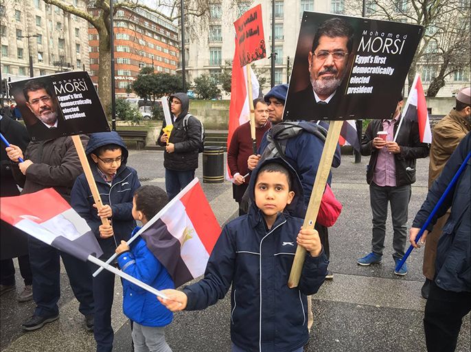 طفل يرفع صور مرسي - إحياء ذكرى ثورة 25 يناير بمسيرات جابت شوارع لندن