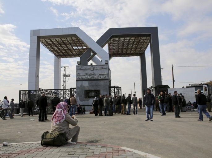 A Palestinian man and others wait outside the gate to cross the border to the Egyptian side at the Rafah crossing, in Rafah City, Gaza Strip, Thursday, Dec. 3, 2015. Egypt has reopened its border with the Gaza Strip in both directions for the first time in months. Thousands of Palestinians are lining up at Rafah border crossing to leave the isolated enclave. (AP Photo/Adel Hana)