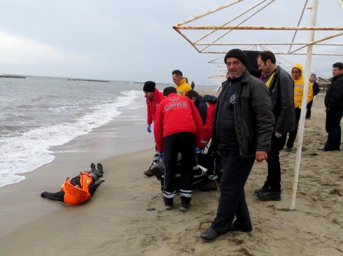 People and gendarmes stand near the body of a drowned refugee after a failed attempt to sail to the Greek island of Lesvos at the shore in the coastal town Ayvalik, in Balikesir, Turkey, 05 January 2016. According to local media, at least 20 people died including children after the boat accident. EPA/STR ATTENTION EDITORS: PICTURE CONTAINS GRAPHIC CONTENT