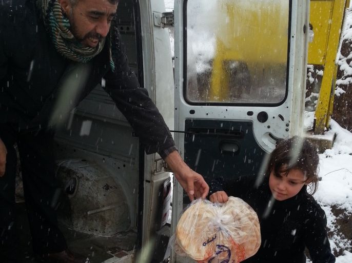 هشام السبسبي يوزع الخبز ويعطي الطفلة ميسم الجويدة ربطة خبز - بلدة السنديانة – أسامة العويد – عكار شمال لبنان .
