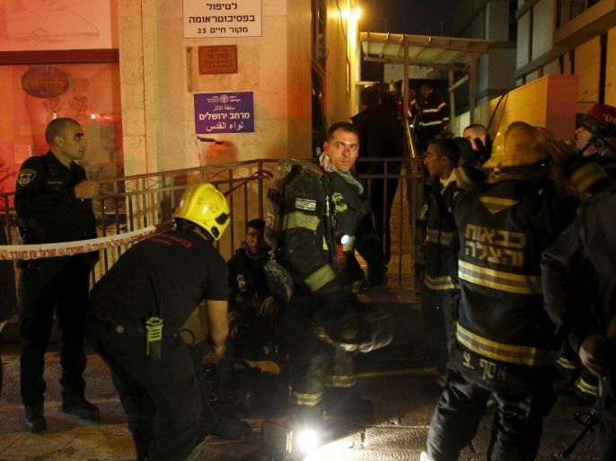 Israeli fire-fighters stand at the entrance to an office building where the offices of B'Tselem is located, in Jerusalem January 10, 2016. A fire broke out on Sunday in the Jerusalem offices of one of Israel's leading human rights groups and authorities were checking whether it was set deliberately, a police spokeswoman said. REUTERS/Ronen Zvulun