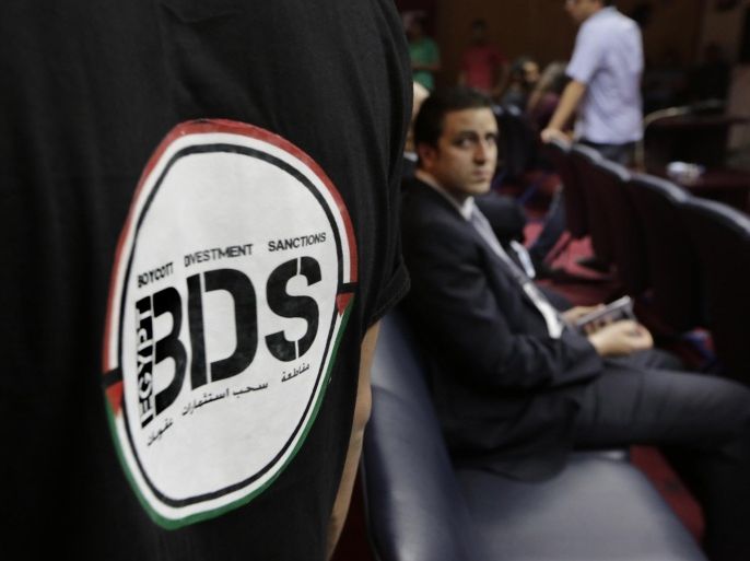 FILE - In this Monday, April 20, 2015 file photo, an Egyptian wears a T-shirt with a logo of BDS (boycott, divestment and sanctions), a campaign started by Palestinian activists to boycott Israel and Israeli-made goods, during the launch of its campaign at the Egyptian Journalists' Syndicate in Cairo, Egypt. The group calls for a global boycott campaign against Israel as a nonviolent method to promote the Palestinian struggle for independence. (AP Photo/Amr Nabil, File)