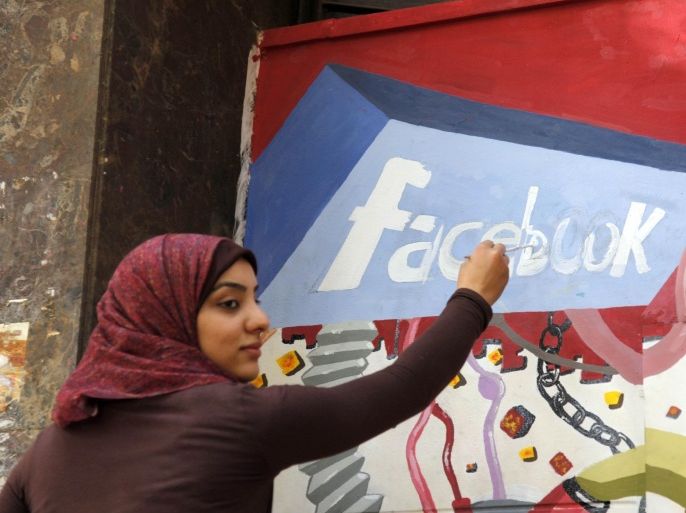 FILE - In this March 30, 2011, file photo. an art student from the University of Helwan paints the Facebook logo on a mural commemorating the revolution that overthrew Hosni Mubarak in the Zamalek neighborhood of Cairo, Egypt. In a statement to The Associated Press on Wednesday, Dec 30, 2015, Facebook said it is “disappointed” that a program providing free basic Internet services to over three million Egyptians has been shut down. It said the service provided Internet access to more than a million people who were not previously connected. (AP Photo/Manoocher Deghati, File)