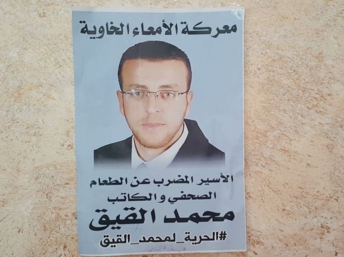 ملصق في بلدة دورا بالخليل جنوبي الضفة الغربية يحمل صورة الصحفي الأسير محمد القيق