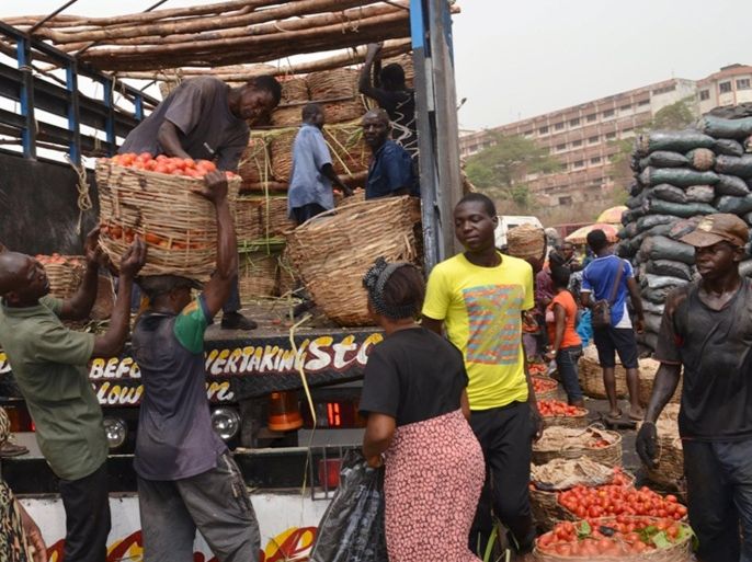 Workers unload tomatoes from a pick-up truck at a market in Enugu, Nigeria February 24, 2016. Nigeria is Africa's second largest tomato producer with 1.5 million tonnes of tomatoes annually, yet 45 percent of the produce will often perish. Tomato processing factories in the country are working to secure the market and keep out cheap imports, but lack of adequate facilities is making it difficult to produce tomato paste, a staple in the West African nation. Picture taken February 24, 2016. REUTERS/StringerEDITORIAL USE ONLY. NO RESALE. NO ARCHIVE
