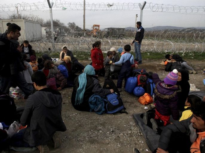 Refugees and migrants rest next to a border fence at the Greek-Macedonian border, following a demand by Macedonia for additional identification from people seeking to cross the border and head to Western Europe, near the village of Idomeni, Greece, February 22, 2016. REUTERS/Alexandros Avramidis