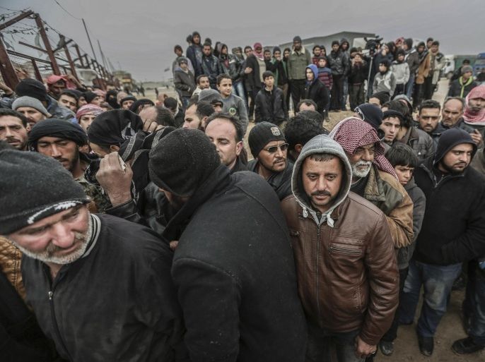 Syrians gather at the Bab al-Salam border gate with Turkey, in Syria, Saturday, Feb. 6, 2016. Thousands of Syrians have rushed toward the Turkish border, fleeing fierce Syrian government offensives and intense Russian airstrikes. Turkey has promised humanitarian help for the displaced civilians, including food and shelter, but it did not say whether it would let them cross into the country. (AP Photo/Bunyamin Aygun) TURKEY OUT