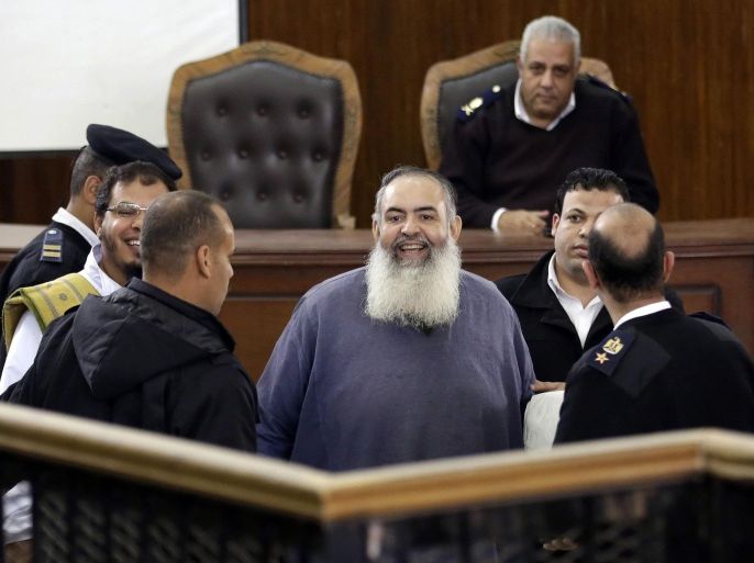 One-time potential presidential candidate, Egyptian Muslim cleric Hazem Salah Abu-Ismail, center, appears in a courtroom accompanied by policemen, in Cairo, Egypt, Saturday, Feb. 28, 2015. The Egyptian court on Saturday sentenced four members of the banned Muslim Brotherhood organization to death and 14 to life in prison. Some 22,000 people have been arrested since Morsi's ouster, including most of the Brotherhood's leaders, as well as non-Islamist activists swept up by police during protests. (AP Photo/Hassan Ammar)