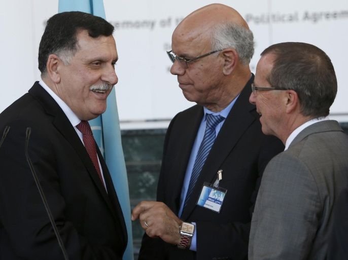 Fayez Sarraj, Libyan Prime Minister, left, chats with Mohammed Chouaib, head of delegation from the UN-recognized government in the eastern city of Tobruk, Libya, center, as UN Special Envoy to Libya, Martin Kobler, right, looks on after signing a U.N.-sponsored deal aiming to end Libya's conflict Thursday , Dec.17, 2015 in Skhirat, Morocco. (AP Photo/Abdeljalil Bounhar)
