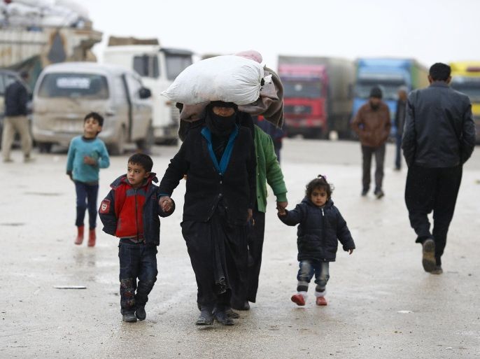 Internally displaced Syrians carry their belongings as they arrive at a refugee camp near the Bab al-Salam crossing, across from Turkey's Kilis province, on the outskirts of the northern border town of Azaz, Syria February 6, 2016. REUTERS/Osman Orsal