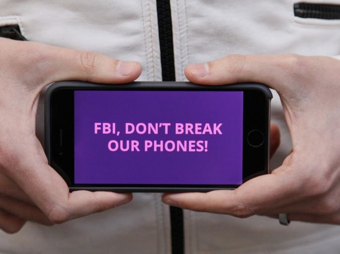 A man holds out his iPhone during a rally in support of data privacy outside the Apple store Tuesday, Feb. 23, 2016, in San Francisco. Protesters assembled in more than 30 cities to lash out at the FBI for obtaining a court order that requires Apple to make it easier to unlock an encrypted iPhone used by a gunman in December's mass murders in California. (AP Photo/Eric Risberg)