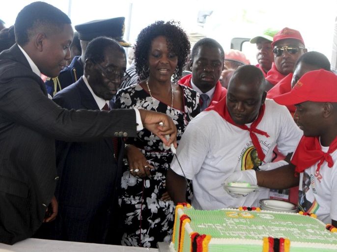 Zimbabwe's President Robert Mugabe and his wife Grace cut a birthday cake at celebrations at Great Zimbabwe in Masvingo, February 27, 2016. Mugabe marked his 92nd birthday at a nearly $1 million party organised by supporters in a drought-stricken area on Saturday, drawing criticism from opponents who said the celebrations were an affront to ordinary Zimbabweans. REUTERS/Philimon Bulawayo