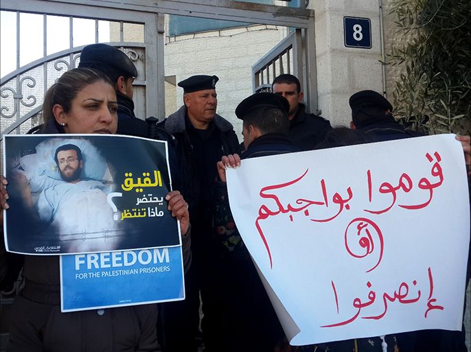 فلسطين رام الله 9 شباط 2016 ناشطة فلسطينية تحمل ملصقا للأٍسير القيق بعد أن تدهورت حالته الصحية جراء إضراب مستمر منذ 77 يوما