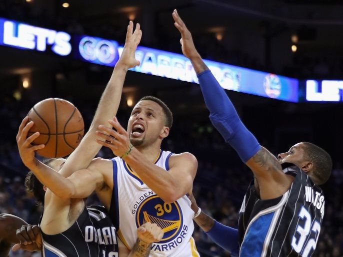 Oakland, California, UNITED STATES : OAKLAND, CA - MARCH 07: Stephen Curry #30 of the Golden State Warriors goes up for a shot against Evan Fournier #10 and C.J. Watson #32 of the Orlando Magic at ORACLE Arena on March 7, 2016 in Oakland, California. NOTE TO USER: User expressly acknowledges and agrees that, by downloading and or using this photograph, User is consenting to the terms and conditions of the Getty Images License Agreement. Ezra Shaw/Getty Images/AFP