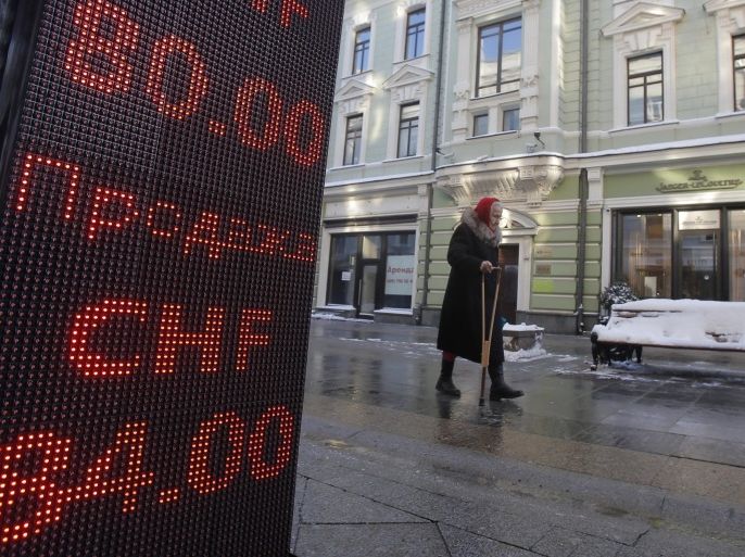 A woman walks past a board showing currency exchange rates of the Swiss franc against the rouble in Moscow, Russia, January 21, 2016. Russia's rouble fell further on January 20, setting a new record low of over 81 roubles per dollar as a bearish mood gripped Russian financial markets. REUTERS/Maxim Shemetov