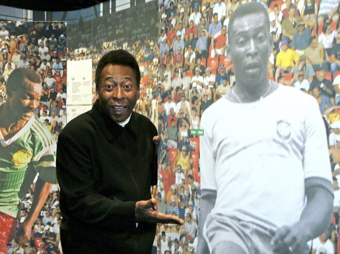 epa000314102 Brazilian soccer legend Pele poses next to a photography of himself in action during the opening of the exhibition '100 Years of Planet Football' at the Olympic Museum in Lausanne, Switzerland, Wednesday 17 November 2004. The year 2004 marks the centenary celebration of the International Association Football Federation (FIFA). The exhibiton presents a historical, social and cultural view of football by retracing the highlights of the World Cup, enabling the visitor to discover the history of FIFA and its many involvements in the development of football worldwide. EPA/MARTIAL TREZZINI