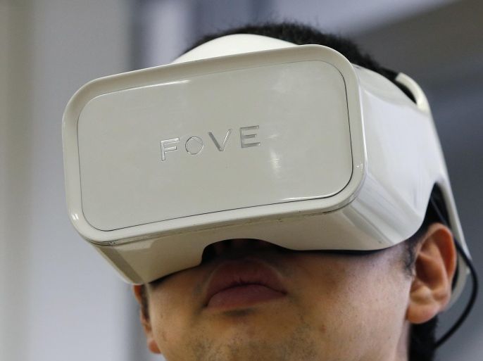 In this March 7, 2016 photo, Fove's staff wearing an eye-tracking headset goggles demonstrates virtual reality at his office in Tokyo. San Francisco-based startup Fove has developed eye-tracking for virtual reality - that kernel of technology many feel is key for the illusion of becoming immersed in a setting. Fove has devised a way to use tiny infrared sensors inside headset goggles to monitor the movements of a wearer’s pupils. (AP Photo/Shizuo Kambayashi)