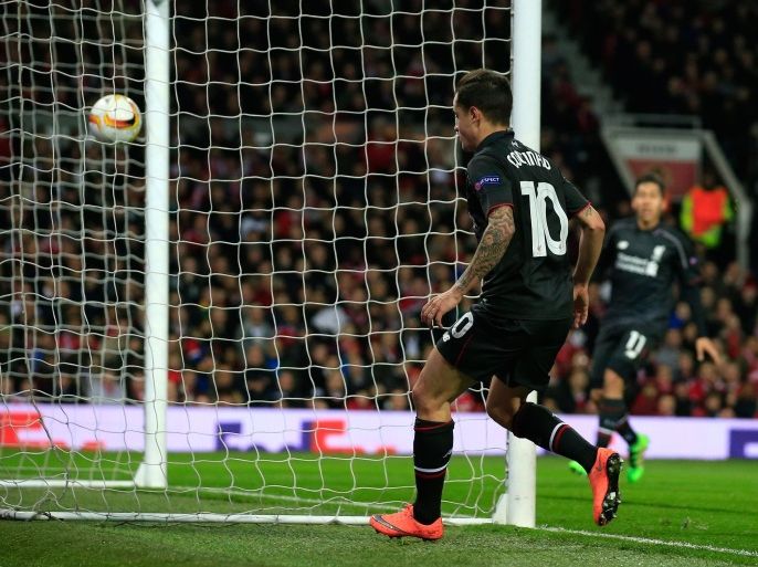 Liverpool’s Philippe Coutinho, center, watches his shot go into the goal for his side’s first goal during the Europa League round of 16, second leg, soccer match between Manchester United and Liverpool at Old Trafford Stadium in Manchester, England, Thursday March 17, 2016. (AP Photo/Jon Super)