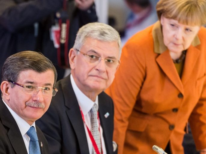 German Chancellor Angela Merkel (R) stands up as EU Leaders with Turkish Prime Minister Ahmet Davutoglu (3-L) during an extraordinary summit of European Union leaders with Turkey in Brussels, Belgium, 07 March 2016. EU leaders are set to make another attempt to stem a migration surge that is testing their unity and principles, with hopes high that neighbouring Turkey will shoulder more of the burden.