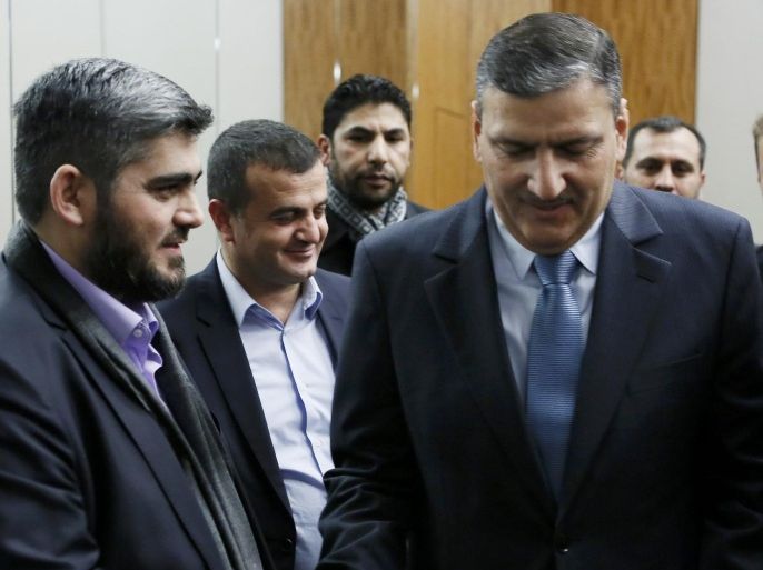 Riad Hijab (R) Syrian opposition coordinator for the High Negotiations Committee (HNC) shakes hand with Mohamed Alloush of the Jaysh al Islam after a news conference after the Geneva peace talks were paused in Geneva, Switzerland, February 3 , 2016. U.N.-mediated talks to end the war in Syria are on pause until Feb. 25, U.N. envoy Staffan de Mistura said on Wednesday, saying the talks had not failed but needed immediate help from international backers led by the United States and Russia. REUTERS/Pierre Albouy
