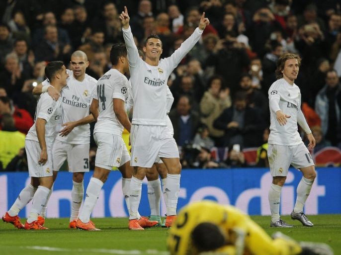 Real Madrid's Cristiano Ronaldo, center, celebrates after scoring the opening goal during the Champions League Round of 16, second leg soccer match between Real Madrid and Roma at the Santiago Bernabeu stadium in Madrid, Tuesday March 8, 2016. (AP Photo/Paul White)