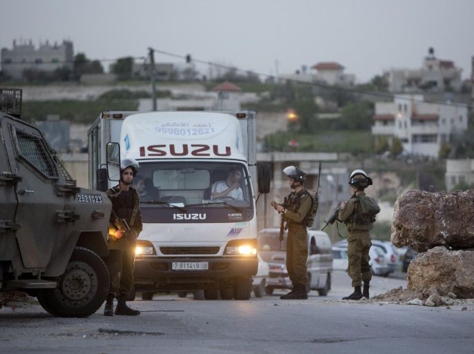 Israeli soldiers check Palestinians at a checkpoint on the road to the village of Hajja near the West Bank city of Nablus, Wednesday, March 9, 2016. Israeli army imposed the blockade after a Palestinian from the village killed an American tourist and wounded nearly a dozen people in the city of Jaffa on Tuesday. (AP Photo/Majdi Mohammed)