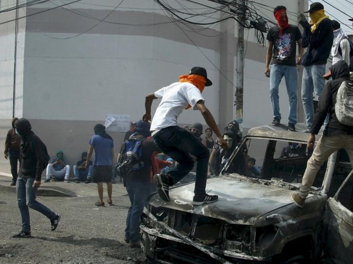 Demonstrators jump on a burned van during a protest against President Nicolas Maduro's government in San Cristobal, Venezuela March 3, 2016. REUTERS/Carlos Eduardo Ramirez FOR EDITORIAL USE ONLY. NO RESALES. NO ARCHIVE.