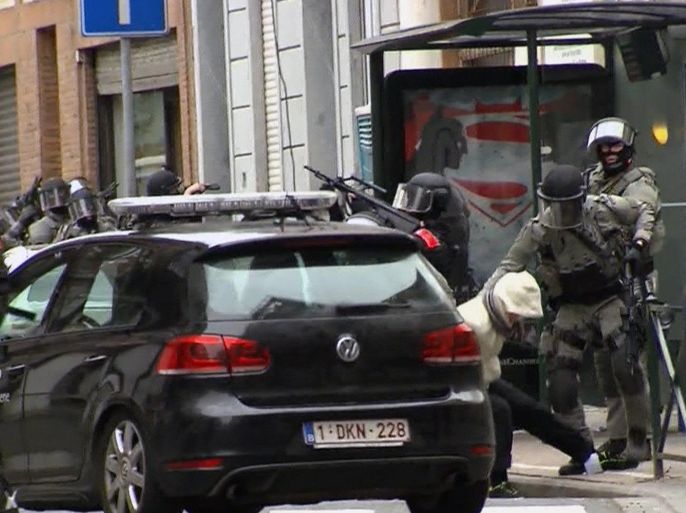 In this framegrab taken from VTM, something appears to drop from inside the trouser leg of Salah Abdeslam as he is arrested by police and bundled into a police vehicle during a raid in the Molenbeek neighborhood of Brussels, Belgium, Friday March 18, 2016. After an intense four-month manhunt across Europe and beyond, police on Friday captured Salah Abdeslam, the top suspect in last year's deadly Paris attacks, in the same Brussels neighborhood where he grew up. (VTM via AP) BELGIUM OUT