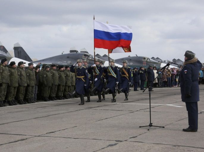 In this photo provided by the Russian Defense Ministry Press Service, guards walk past a lineup of troops during a welcome ceremony for Russian military personnel who returned from Syria at an airbase near the Russian city Voronezh, Tuesday, March 15, 2016. Russian warplanes and troops stationed at Russia's air base in Syria started leaving for home on Tuesday after a partial pullout order from President Vladimir Putin the previous day, a step that raises hopes for progress at the newly reconvened U.N.-brokered peace talks in Geneva. (Russian Defense Ministry Press Service via AP)