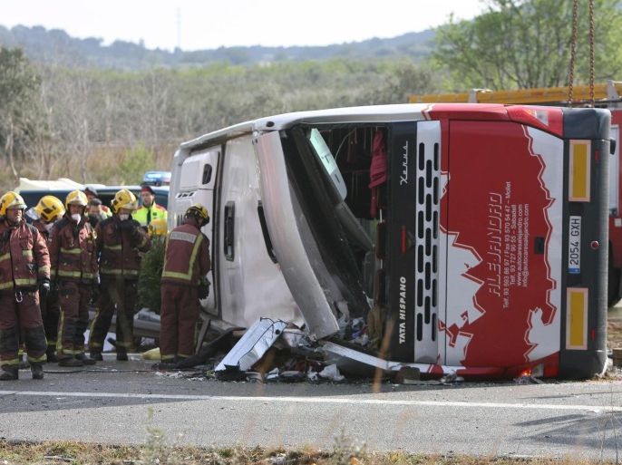 Firemen work at the site of a coach crash that has left at least 14 students dead at the AP-7 motorway in Freginals, in the province of Tarragona, northeastern Spain, 20 March 2016. The coach carrying dozens of Erasmus students collided with a car and overturned. The students from several different countries were heading to Barcelona after attending Las Fallas Festival in Valencia, eastern Spain.