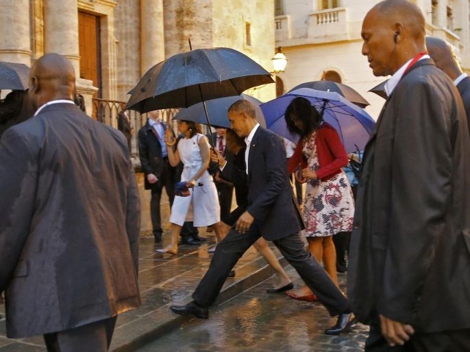 U.S. President Barack Obama steps over a puddle while touring Old Havana with his family, in Havana March 20, 2016. REUTERS/Carlos Barria