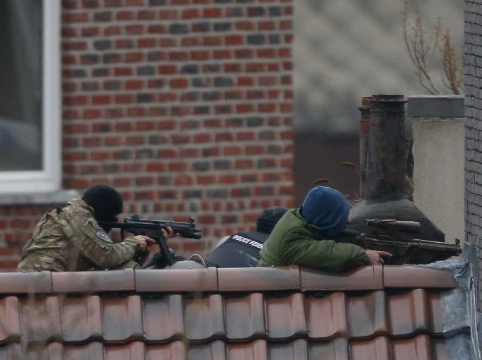 Police officers take position on a rooftop during a police operation in Forest, Brussels, Belgium, 15 March 2016. A major police operation was underway after shots were fired during an anti-terror raid in Brussels linked to the 13 November Paris Attacks. At least two officers were slightly injured, police said. The French Interior Minister confirmed that French Police were taking part in the operation alongside their Belgian colleagues.