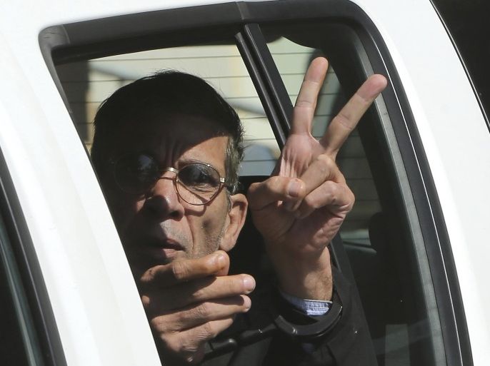 EgyptAir plane hijacking suspect Seif Eddin Mustafa flashes the victory sign as he leaves a court in a police car after a remand hearing as authorities investigate him on charges including hijacking, illegal possession of explosives and abduction in the Cypriot coastal town of Larnaca Wednesday, March 30, 2016. Mustafa described as "psychologically unstable" hijacked a flight Tuesday from Egypt to Cyprus and threatened to blow it up. His explosives turned out to be fake, and he surrendered with all passengers released unharmed after a bizarre six-hour standoff. (AP Photo/Petros Karadjias)