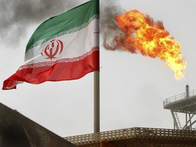 Gas flares from an oil production platform at the Soroush oil fields with an Iranian flag in the foreground in the Persian Gulf, 1,250 km (776 miles) south of the capital Tehran in this July 25, 2005 file photo. Iran's top crude buyers in Asia have just weeks to come up with ways, which have proved elusive so far, to keep the imports flowing without falling foul of the toughest Western sanctions to date against Tehran's oil trade, reported June 6, 2012. Picture taken July 25, 2005. To match Analysis IRAN-OIL/ASIA REUTERS/Raheb Homavandi/Files (IRAN - Tags: ENERGY BUSINESS)
