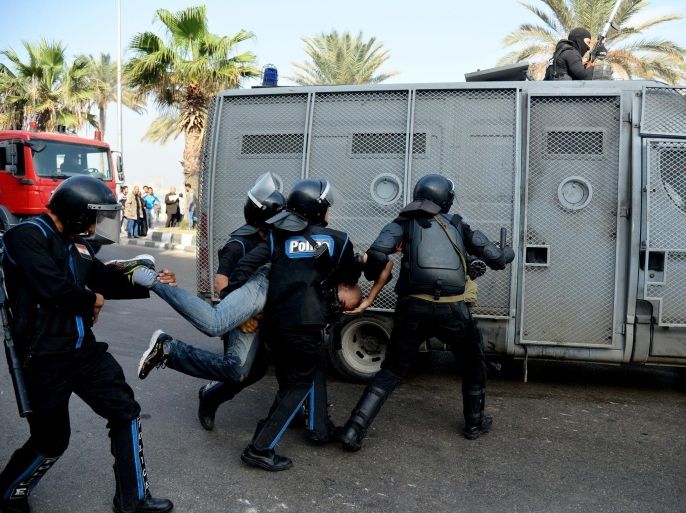 Egyptian riot police detain a protester as they disperse a demonstration in Alexandria, Egypt, Monday, Dec. 2, 2013. Black clad riot police fired tear and chased dozens of rights activists and protesters who held a demonstration in the Mediterranean city demanding abolishing a new law that extensively restricted the right to hold a protest, imposing fines and jail terms on violators.(AP Photo/Heba Khamis)
