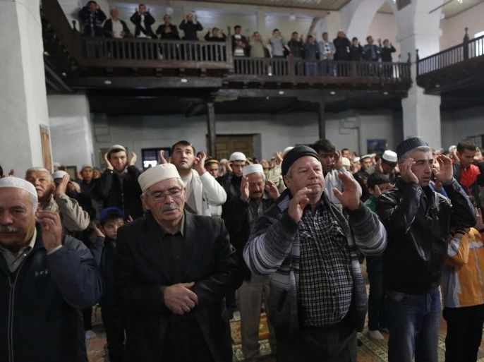 Crimean Tatars pray in a mosque marking the Eid al-Adha, celebrated by Muslims worldwide, in Bakhchisarai, Crimea, Saturday, Oct. 4, 2014. (AP Photo/Max Vetrov)