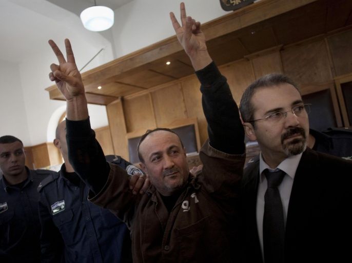 FILE - In this Wednesday, Jan. 25, 2012 file photo, senior Fatah leader Marwan Barghouti makes the victory sign in front of the media during his arrival to testify in a trial at a Jerusalem court. On Wednesday, Nov. 12, 2014, Barghouti, a Palestinian leader serving a life sentence in Israel for his role in the Palestinian uprising last decade, was sentenced to a week in solitary for calling for more violence and for the Palestinian Authority to stop its security cooperation with Israel. Israeli media interpreted that as a call for a third Intifada, or Palestinian uprising. (AP Photo/Bernat Armangue, File)