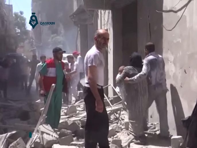This image made from video released by Qasion News Agency, a media opposition platform that relies on a network of activists on the ground, on Friday, April 29, 2016 shows people scrambling through rubble following airstrikes in Aleppo, Syria. Insurgents shelled a mosque in a government-held neighborhood of Aleppo, killing at least 15 people as they left Friday prayers, while government airstrikes struck rebel-held parts of Syria's largest city — even as the army unilaterally declared a brief truce in other parts of the country. (Qasion News Agency via AP)