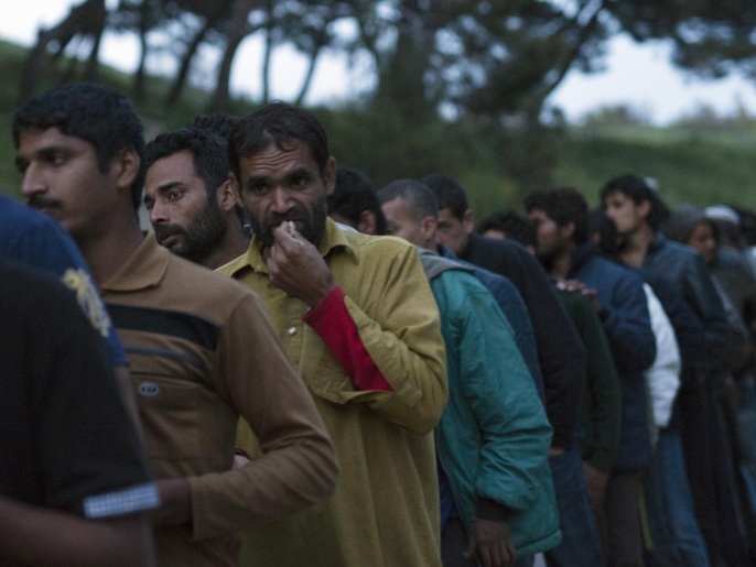 ‪لاجئون يقفون في طابور للحصول على الطعام بأحد المخيمات في جزيرة ليسبوس اليونانية‬ (أسوشيتد برس)