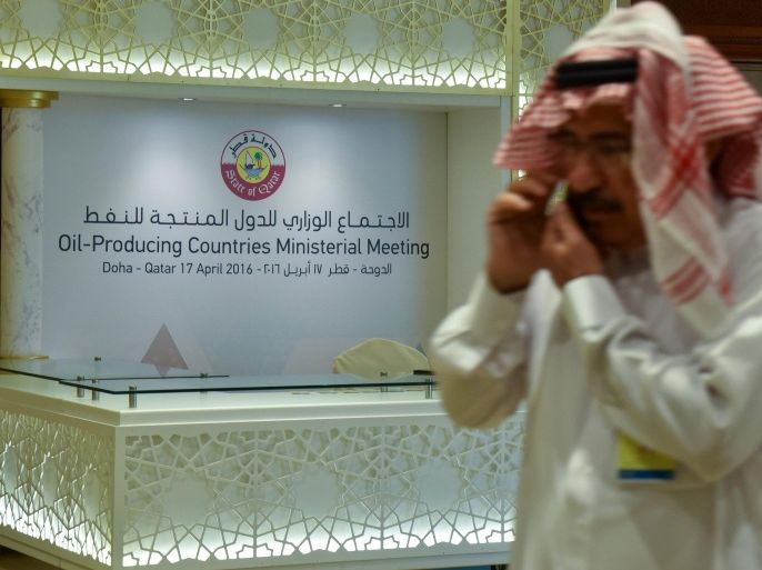 A man walks past a banner for the oil-producers meeting in Doha, Qatar, 17 April 2016. Reports state top oil exporters, including members of the Organization of Petroleum Exporting Countries (OPEC), are meeting in Qatar to discuss freezing output.
